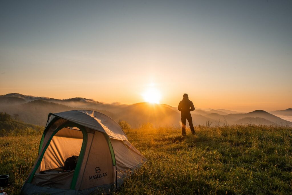 man camping looking at sunrise