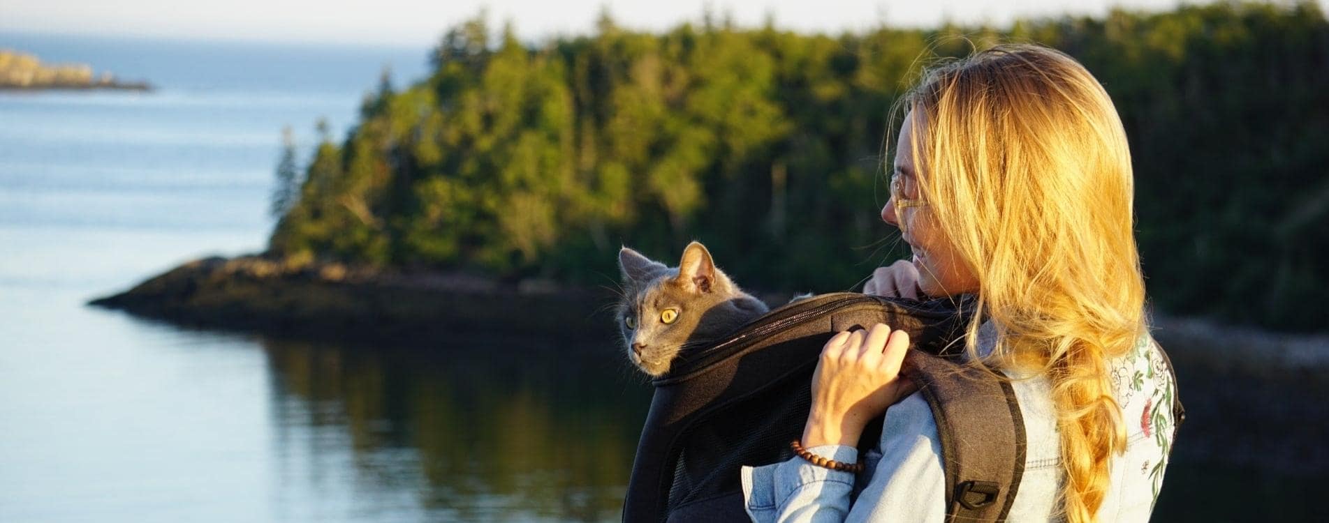 blonde woman hiking with her cat in a cat backpack
